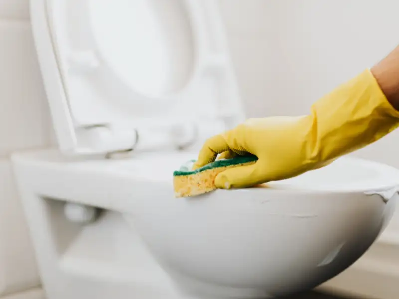 Washroom toilet being scrubbed and disinfected during bathroom cleaning in Indore